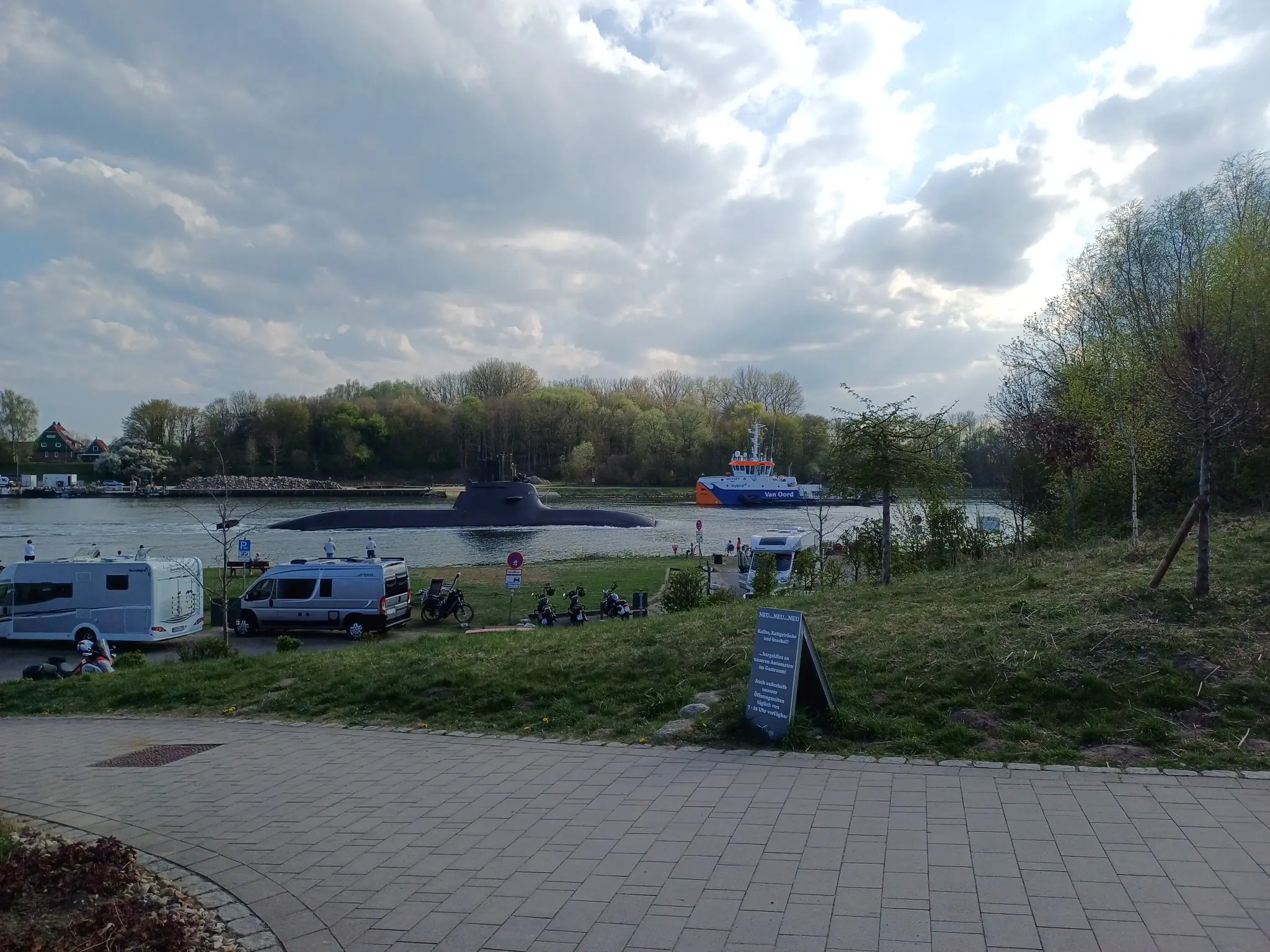 U-Boot und Van-Oord-Schiff auf dem Nord-Ostsee-Kanal bei Kiel mit Wohnmobilen am Ufer